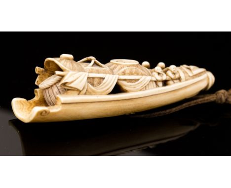 A 19th Century ivory netsuke, carved as a fishing boat with figures and baskets, length 11cm