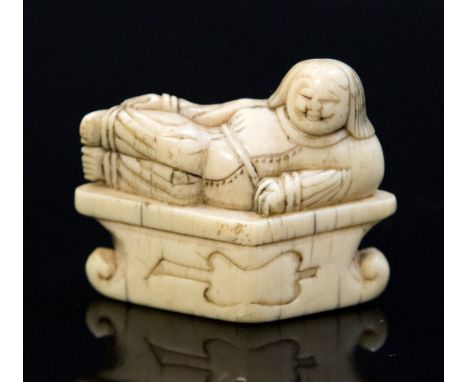 An antique Oriental ivory netsuke, carved as Hotei reclining on a plinth, width 4.5cm, retaining old label 'Ex Collectis T.L.