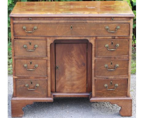 A George III mahogany kneehole desk, circa 1770, the top with a brushing slide over a single long drawer and six short drawer