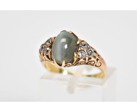 A CATS EYE CRYSOBERYL AND DIAMOND RING, designed with a central oval cut cats eye chrysoberyl flanked with old cut diamonds a