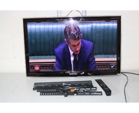 A SAMSUNG UE32C FSTV with remote, attached wall bracket, a spare bracket and a black glass TV stand (PAT pass and working)
