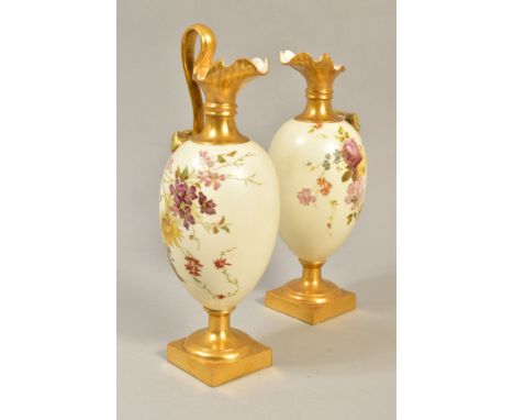 A PAIR OF ROYAL WORCESTER BLUSH IVORY PITCHERS, ref 1144, one having broken handle (not present), both having wear to the gil