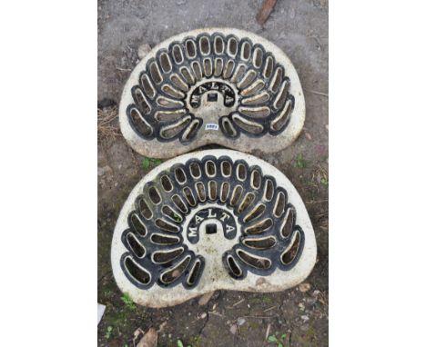 A PAIR OF VINTAGE CAST IRON TRACTOR SEATS stamped MALTA and over painted in cream and black, 46cm across (2)