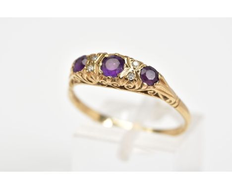 A 9CT GOLD RING, the boat ring set with three circular cut amethyst interspaced with melee diamonds and scrolling gallery, wi
