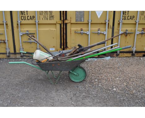 A GALVANISED WHEEL BARROW containing garden tools, a blow lamp, halogen light, etc (15+)