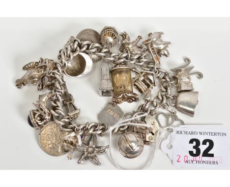 A VINTAGE CHARM BRACELET WITH TWENTY NINE CHARMS, to include a hinge lid lamp, bird cage, Broadway signpost etc, approximate 