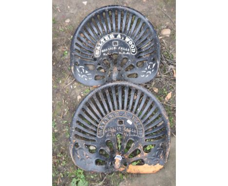 A PAIR OF VINTAGE CAST IRON TRACTOR SEATS stamped Walter A Wood, Hoosick Falls N Y. U. S.A., 43cm across (2)