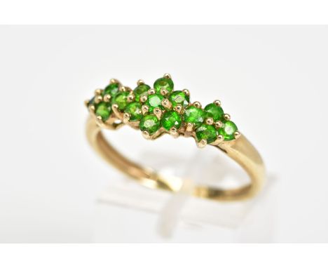 A 9CT GOLD RING, designed as a cluster row of circular cut demantoid garnets, to the plain polished band, with a 9ct hallmark