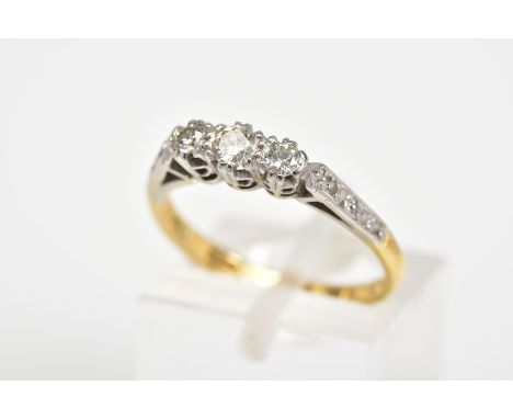A THREE STONE DIAMOND RING, designed as a row of three brilliant cut diamonds, to the diamond set shoulders and plain polishe