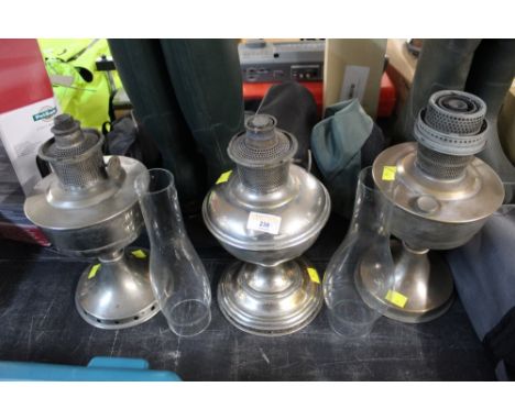 Three vintage oil lamps and two chimneys 