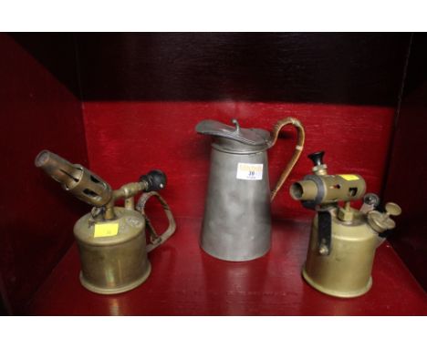 Two vintage brass blow torches and a pewter water jug 