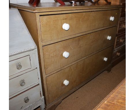 A 19th century grained pine chest of three graduated long drawers with ceramic knobs, on bracket feet, 42" wide