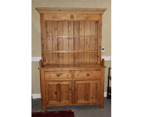 A stripped pine dresser, the upper section fitted two shelves over two drawers and cupboards, on bracket support, 52" wide