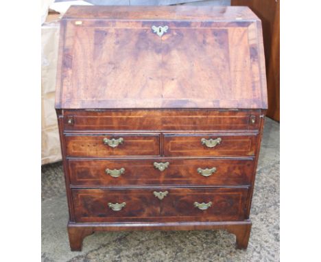 A George II walnut and banded fall front bureau, the interior fitted well and six drawers with central cupboard over two shor
