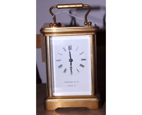 A mid 20th century Garrard & Co brass four-glass carriage clock with swing handle, white dial with black Roman numerals and h