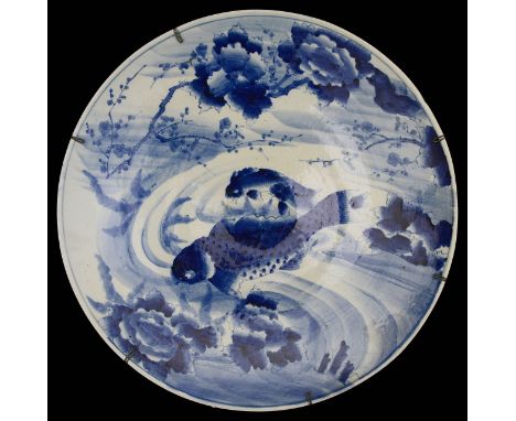 A large late 19th century Japanese blue and white Arita porcelain chargerpainted with three carp swimming amongst weed  frame