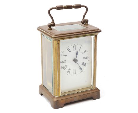 An early 20th century French gilt brass carriage clockthe white enamel dial with Roman numerals and minute markers, case door