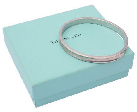 A Tiffany sterling silver concave bangle dated 1997, stamped 925 T &amp; Co 1837, contained within a fitted original card cas