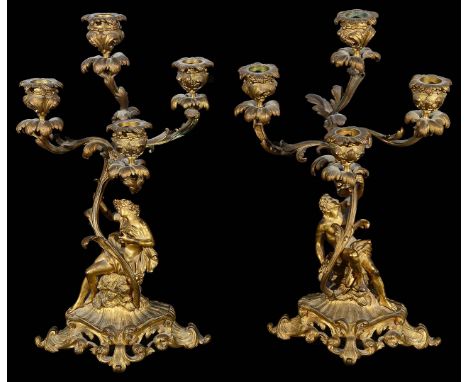 A pair of 19th century French Rococo ormolu figural four light candelabracast as male and female classical figures in flowing