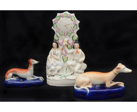 Two 19th century Staffordshire recumbent greyhound pen stands and flatback clock group, (3)first length 20 cm.Condition: Larg