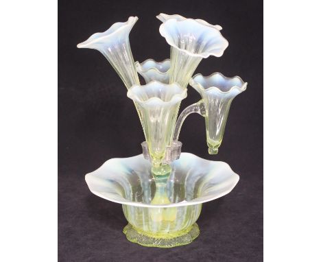 A Victorian yellow glass epergne with three large and three small trumpet shaped vases with wavy rims, raised on a central co