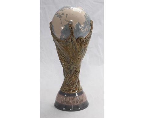 A rare Lladro porcelain copy of the FIFA World Cup, together with a photograph of England?s most capped player, Peter Shilton