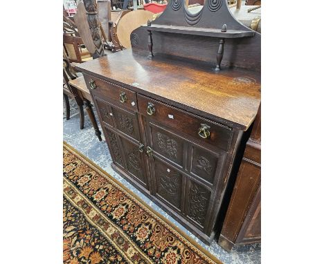 A Victorian oak chiffonier with a carved panel front. 