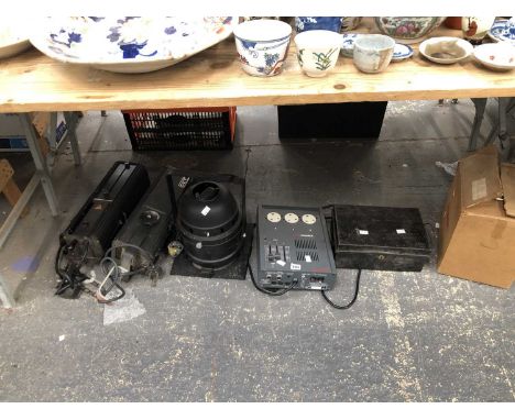 Three spotlights, an Alphapack lighting control deck, a cash box, and a movie projector.