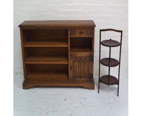 CARVED OAK SIDE CABINET
with a moulded top above three open shelves and a frieze drawer with an open shelf below and a carved