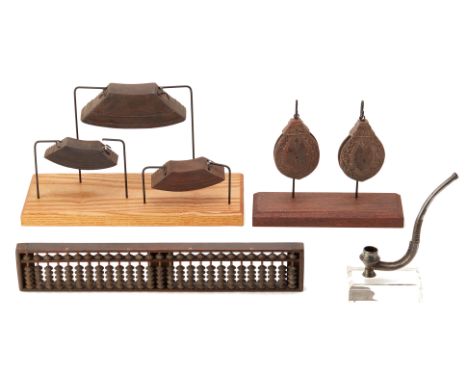 A GROUP OF SOUTH EAST ASIAN ITEMS
Comprising of an abacus, 3 cow bells on stand, 2 Ikat pulleys on stand, and a metal opium p