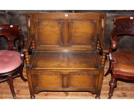 Carved oak monks bench with bobbin pillars.