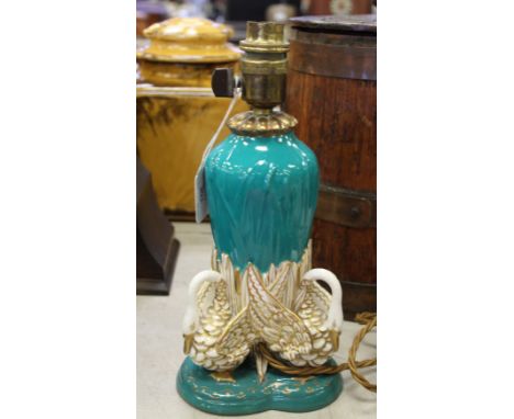 A unusual late Victorian Royal Worcester porcelain lamp base, modelled with swans on a green and gilt ground, now converted t