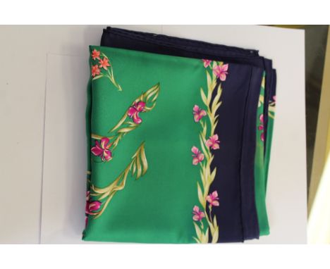 A Hermes silk scarf, printed with a foliate design on a green ground within a blue border 88cm x 88cm Some staining.