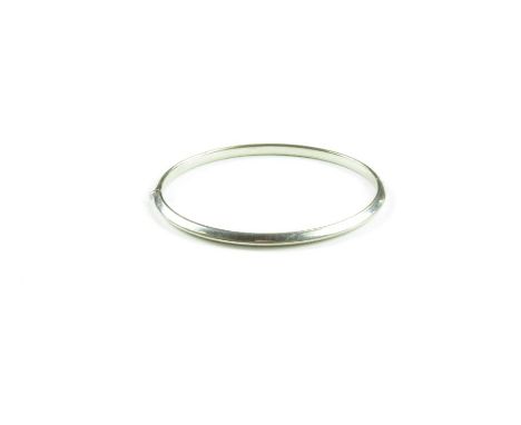 A white metal hinged bangle, marked '750', 6.61g gross
