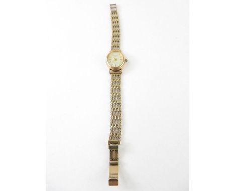 A ladies 9ct gold Rotary Elite wrist watch, the oval champagne dial with gold baton hour markers and hands, on patterned link
