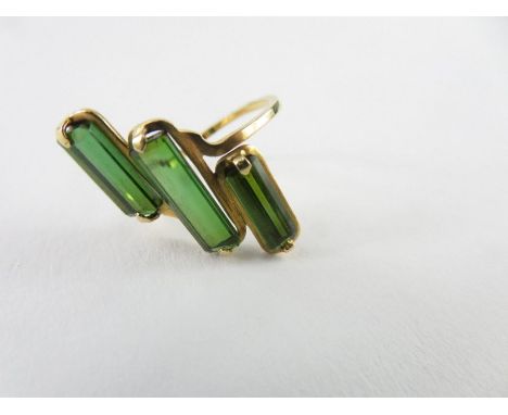 A three stone green tourmaline dress ring, the central stone approximately 12.8mm x 4.4mm, the other two stones approximately