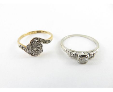 A single stone diamond ring, the white mount stamped ‘14K’, the brilliant cut with a small single cut diamond to either side,