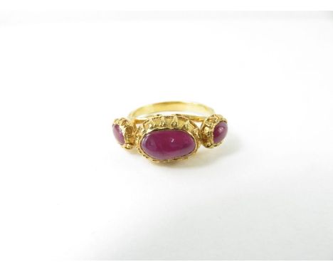 A ruby three stone ring, the three oval cabochon cut rubies set into decorative rub over mounts, finger size M 1/2, mount tes