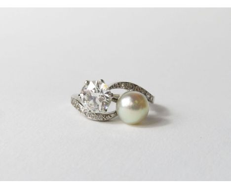 A diamond and natural pearl two stone cross over ring, in unmarked white metal, the pearl measuring approximately 7.8mm diame