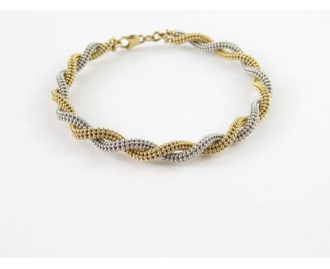 A 9ct yellow and white gold twisted bangle, 5.5mm wide, 7cm diameter, 10.91g gross