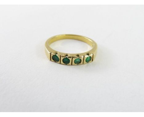 An emerald four stone ring, each round cut emerald approximately 2.2mm, the shank marked '18k', finger size K 1/2, 3.19g gros