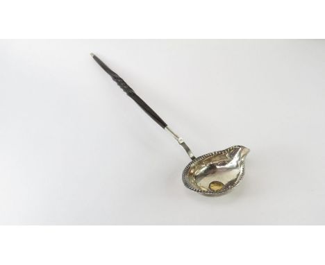 A punch ladle, the coin set bowl to a horn twist handle, 32 cm long