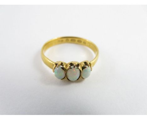 A 22 carat gold three stone opal ring, the central oval cabochon cut stone approximately 4.6 mm x 3.6mm, finger size Q1/2, 3.