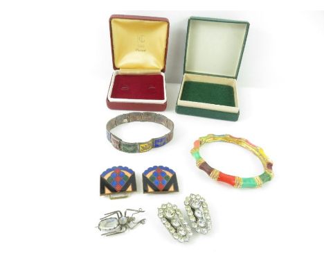 A Siamese multi coloured enamel bracelet; a hinged bangle; a pair of paste clips; an enamel metal buckle; and a bug brooch  