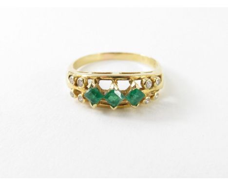 An emerald and diamond dress ring, the three square cut emeralds each approximately 3mm x 3mm, with small round diamonds to e