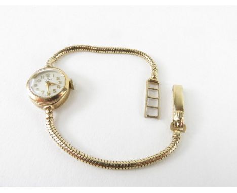 A ladies 9ct gold vintage Tudor wrist watch, the round champagne dial with gold Arabic numerals and hands, on a slim snake ch