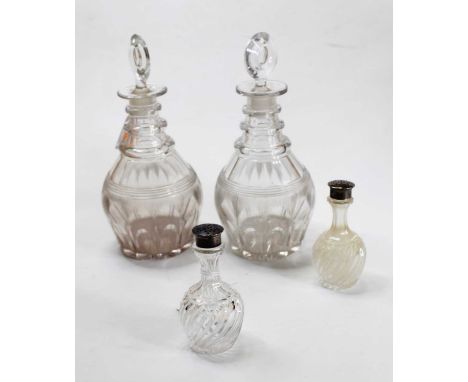 A pair of Regency triple neck decanters, each with facet cut decoration; together with a pair of silver topped cut glass salt