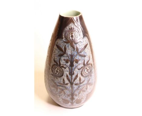 A late Victorian C.H. Brannam Barnstaple art pottery vase, on a dark brown ground relief decorated with flowers, having incis