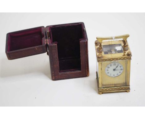 An early 20th century lacquered brass cased carriage clock, having a circular enamelled dial with Arabic numerals, within eng