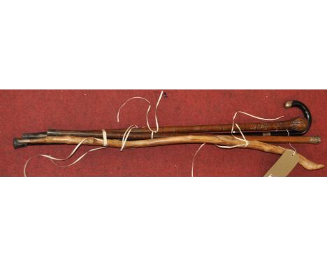 An early 20th century walking stick having a malacca shaft and white metal cap, together with one other ebony walking stick w